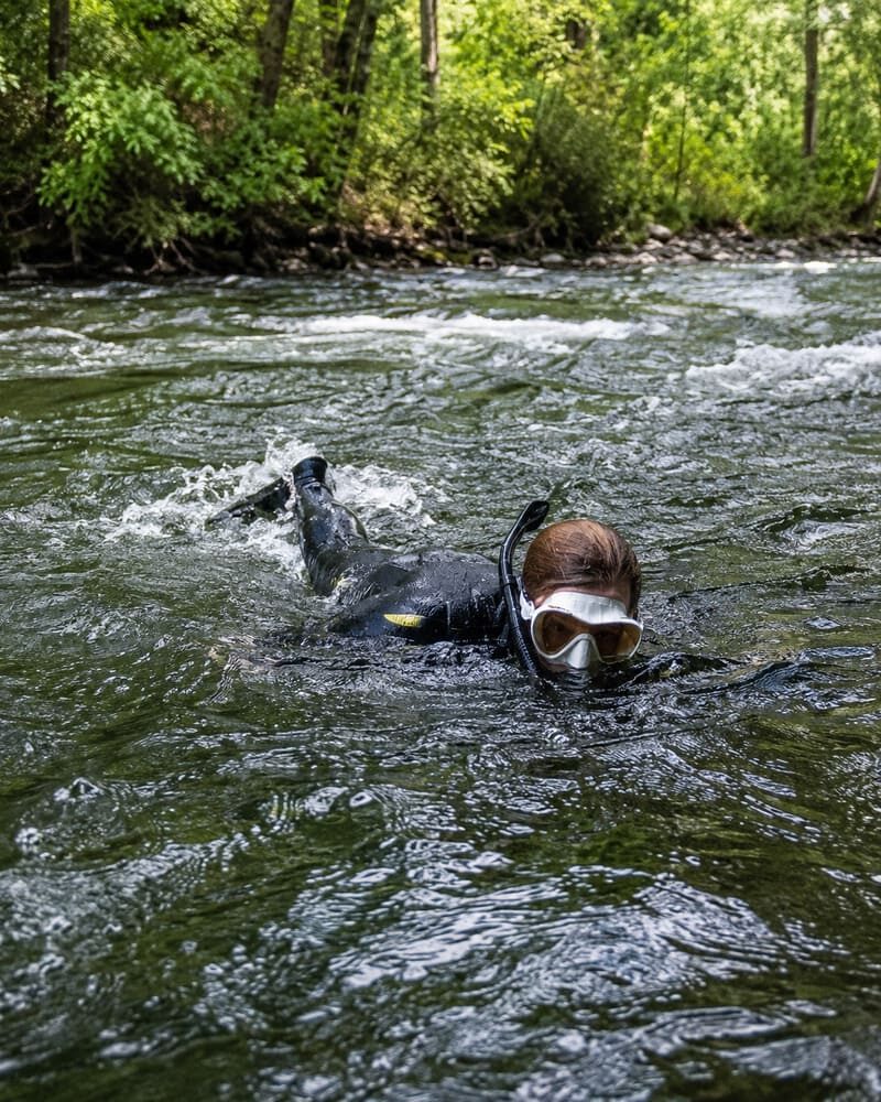 Schnorchler schwimmt gegen die Strömung eines Flusses